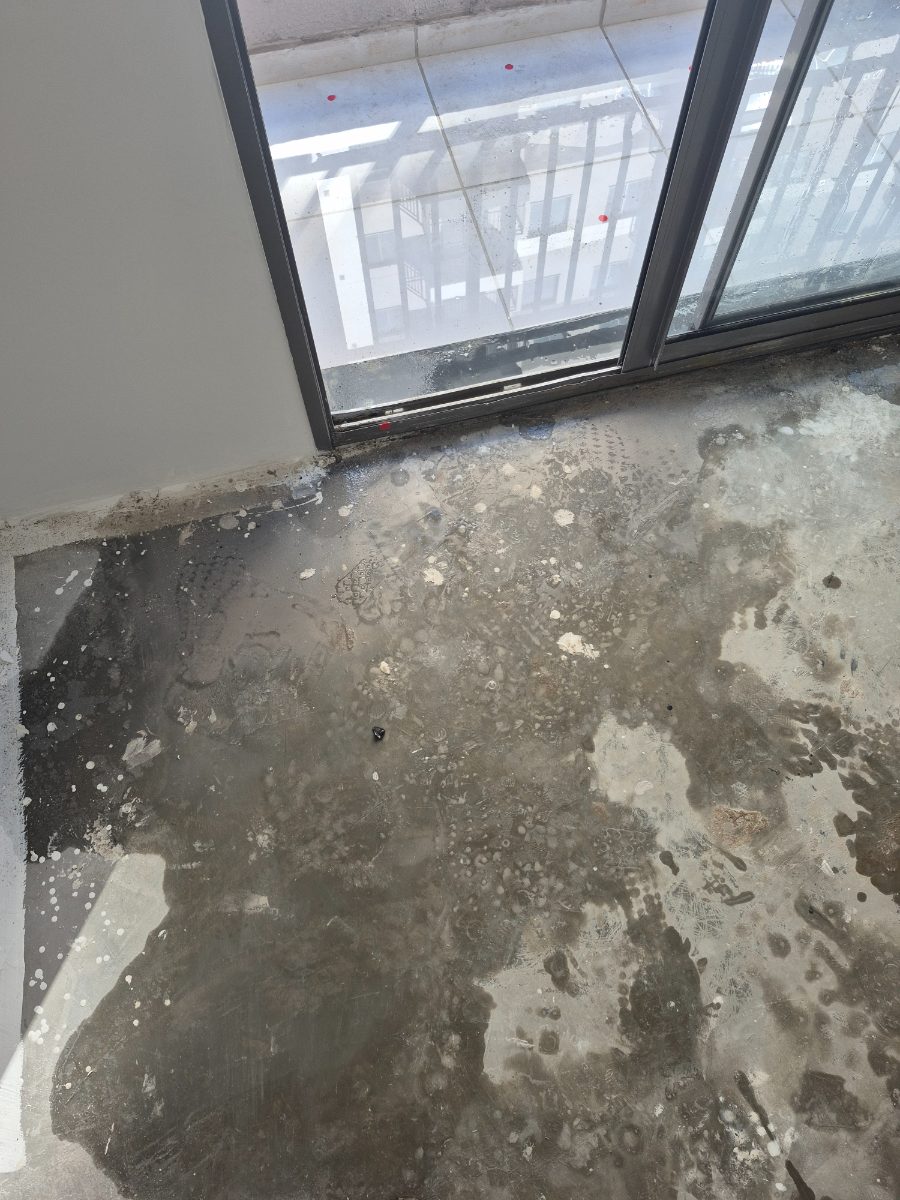Piso molhado junto à porta-balcão, com marcações vermelhas no caixilho